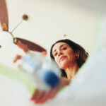 Kobieta wyrzuca plastikową butelkę do kosza na śmieci w domu